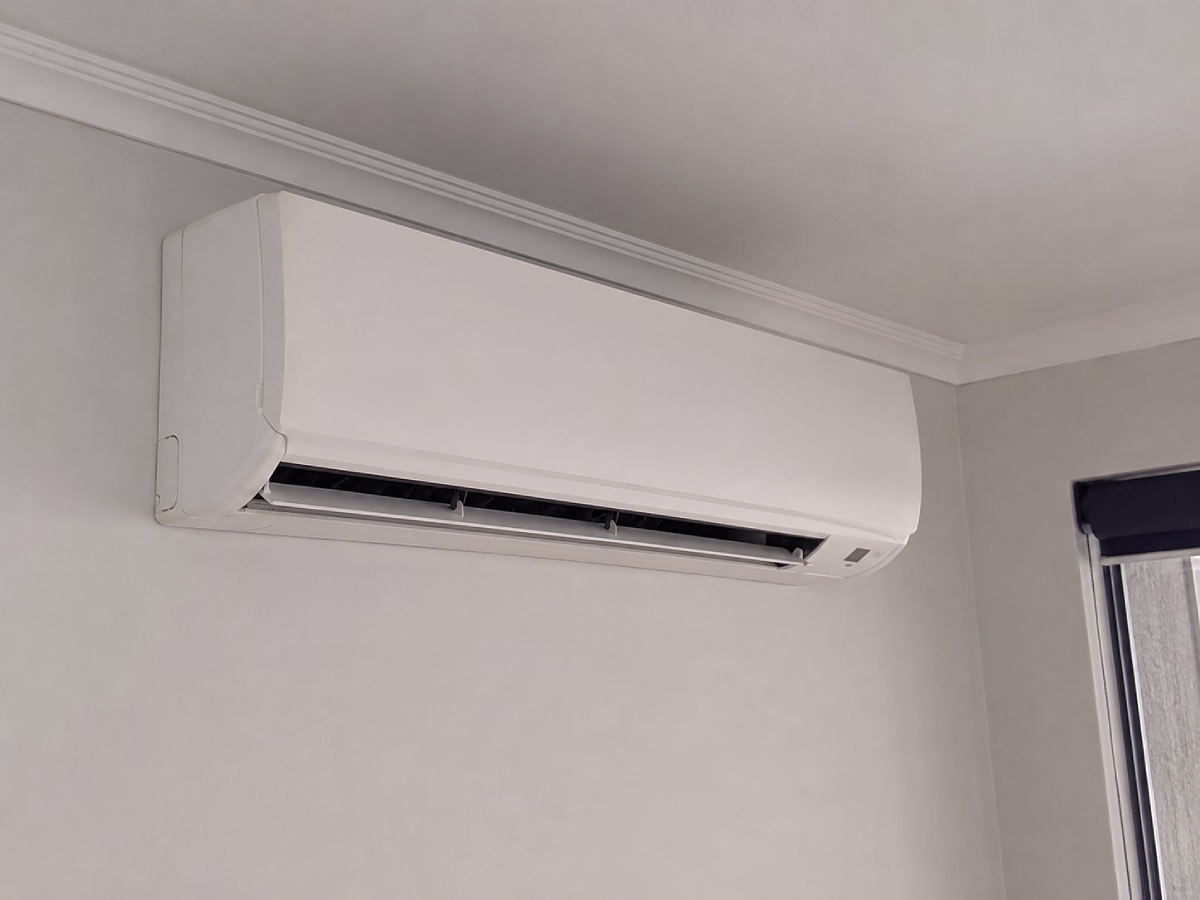 White wall-mounted split-system indoor unit installed neatly near the ceiling
